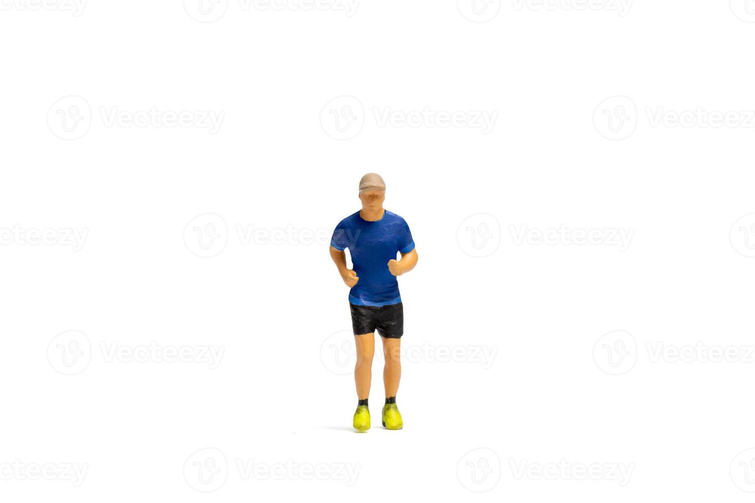 Gente en miniatura, hombre en ropa deportiva corriendo sobre fondo blanco. foto