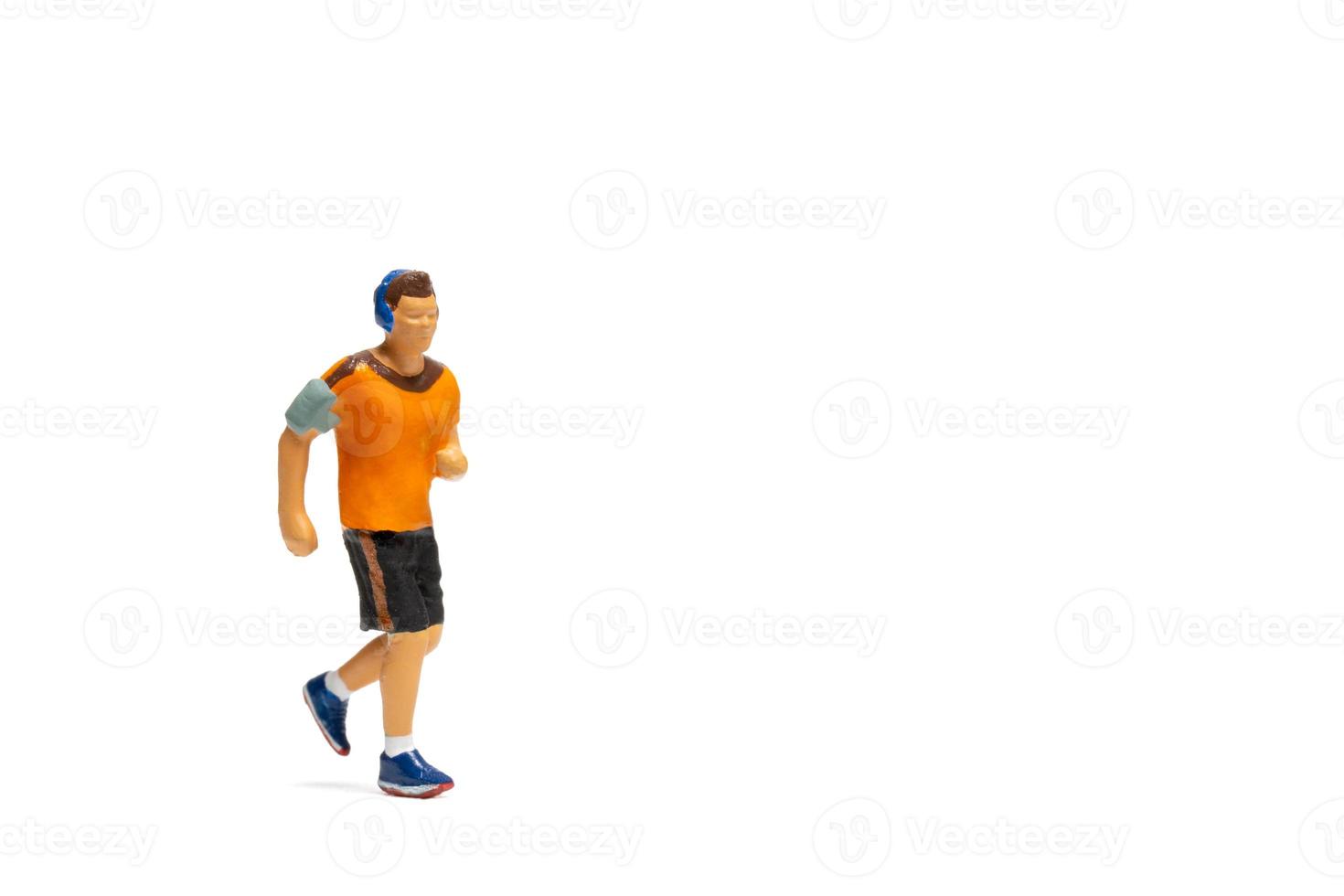 Miniature people, Man in fitness wear running on white background photo