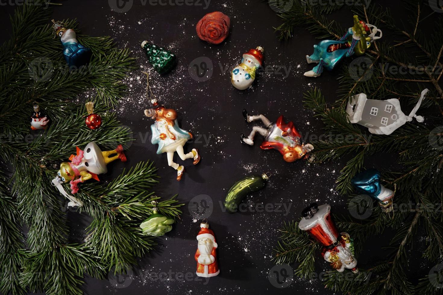 Hermosas figuras festivas como adornos de vidrio para el árbol de Navidad en la mesa de madera oscura. foto