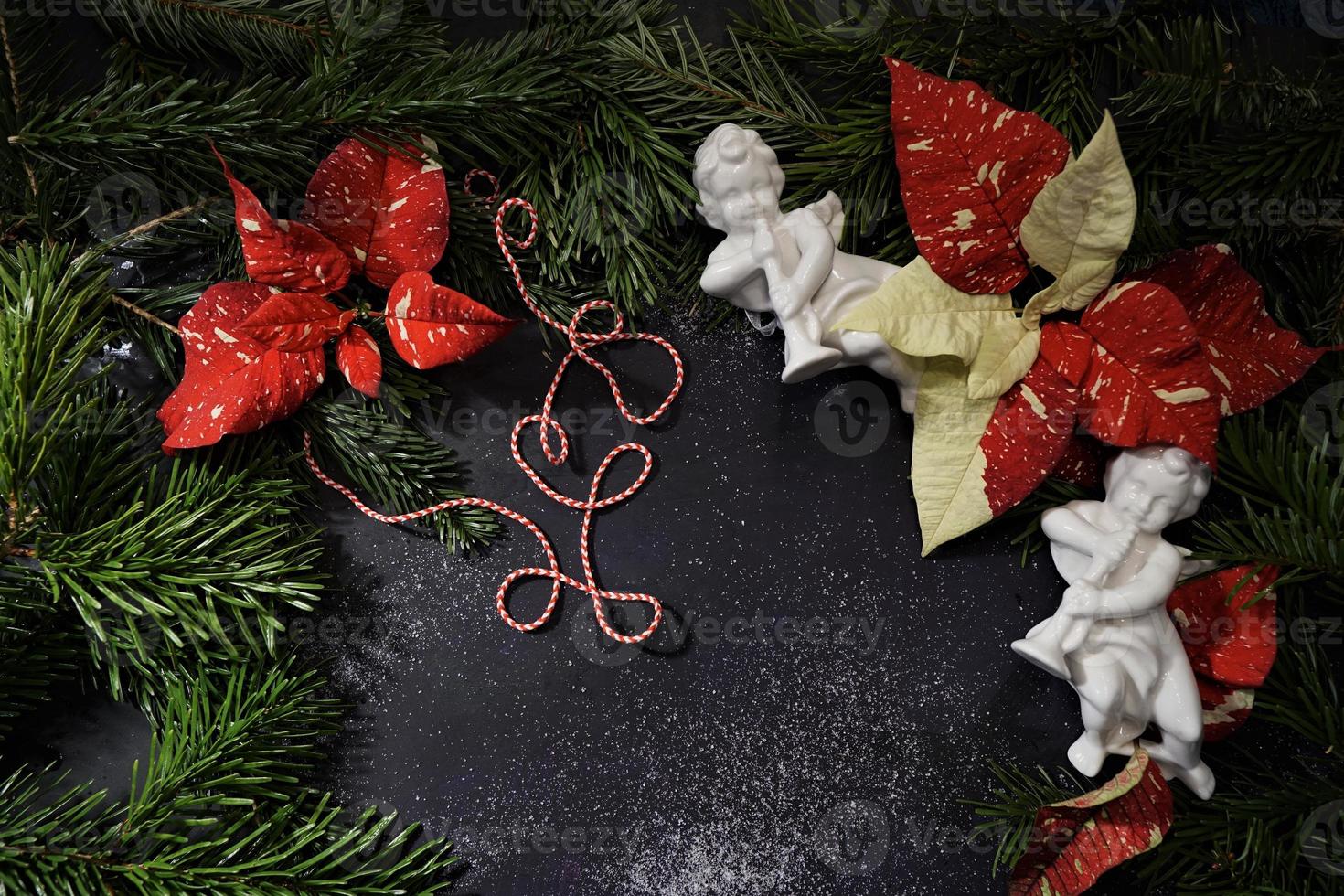 Beautiful Red-White Poinsettie, Ceramic Angel And Green Christmas Tree Branches. Euphorbia Pulcherrima, Festive Floral Background. photo