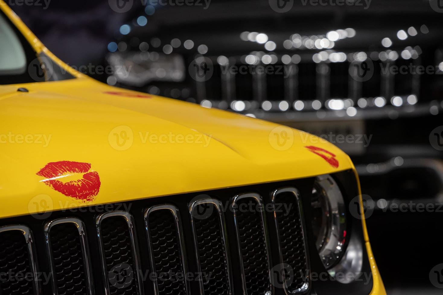 Part of a yellow car is pasted with red lips photo