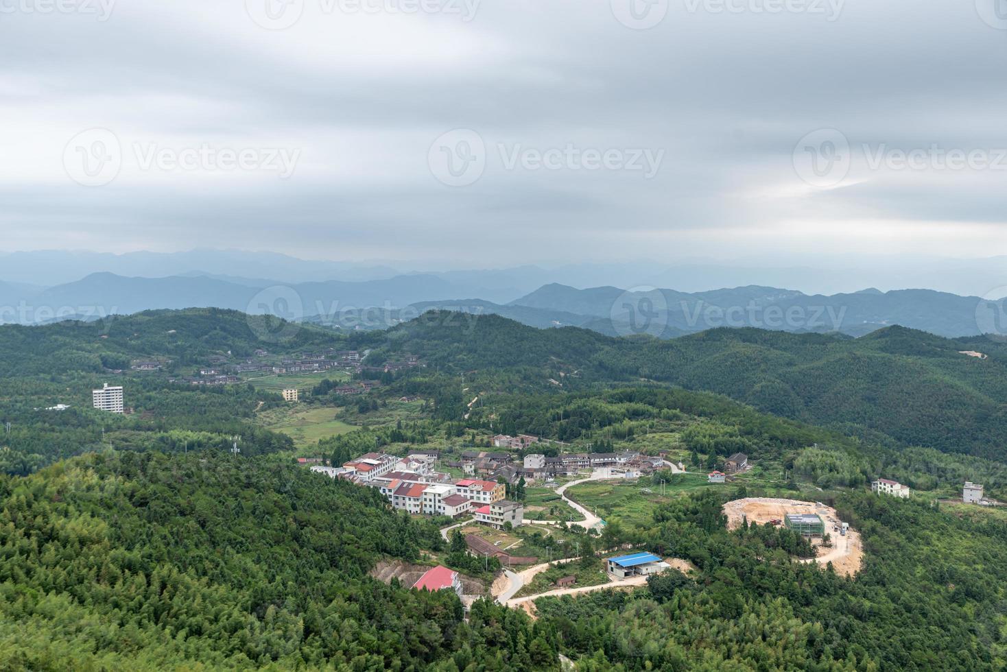 A country surrounded by forests on a cloudy day photo