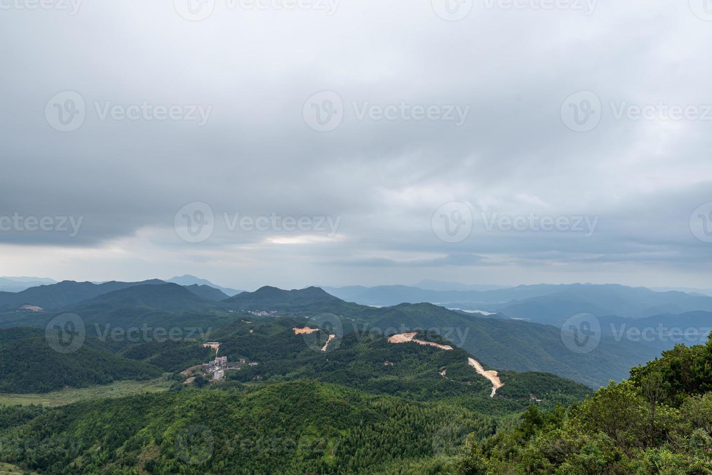 A country surrounded by forests on a cloudy day photo