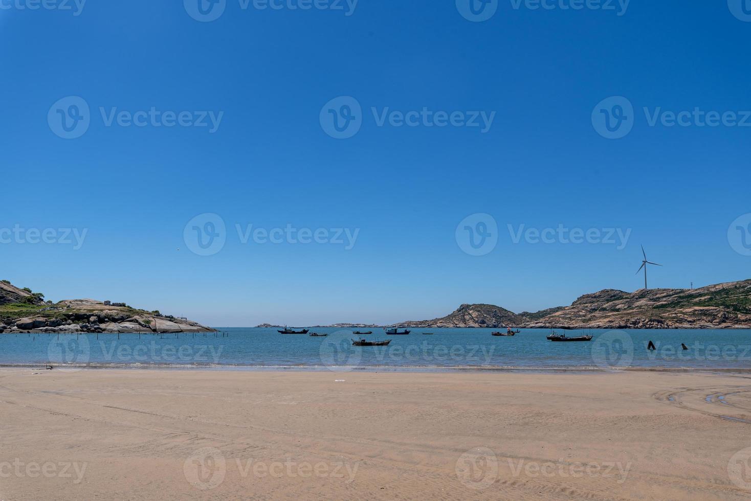 The sea under the blue sky, clean beaches and sea water, as well as islands and windmills photo