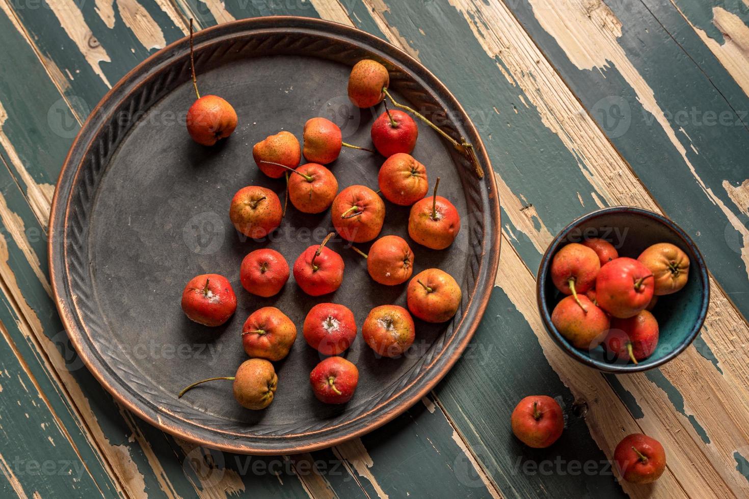 Red hawthorn on a plate or scattered on a wooden table photo