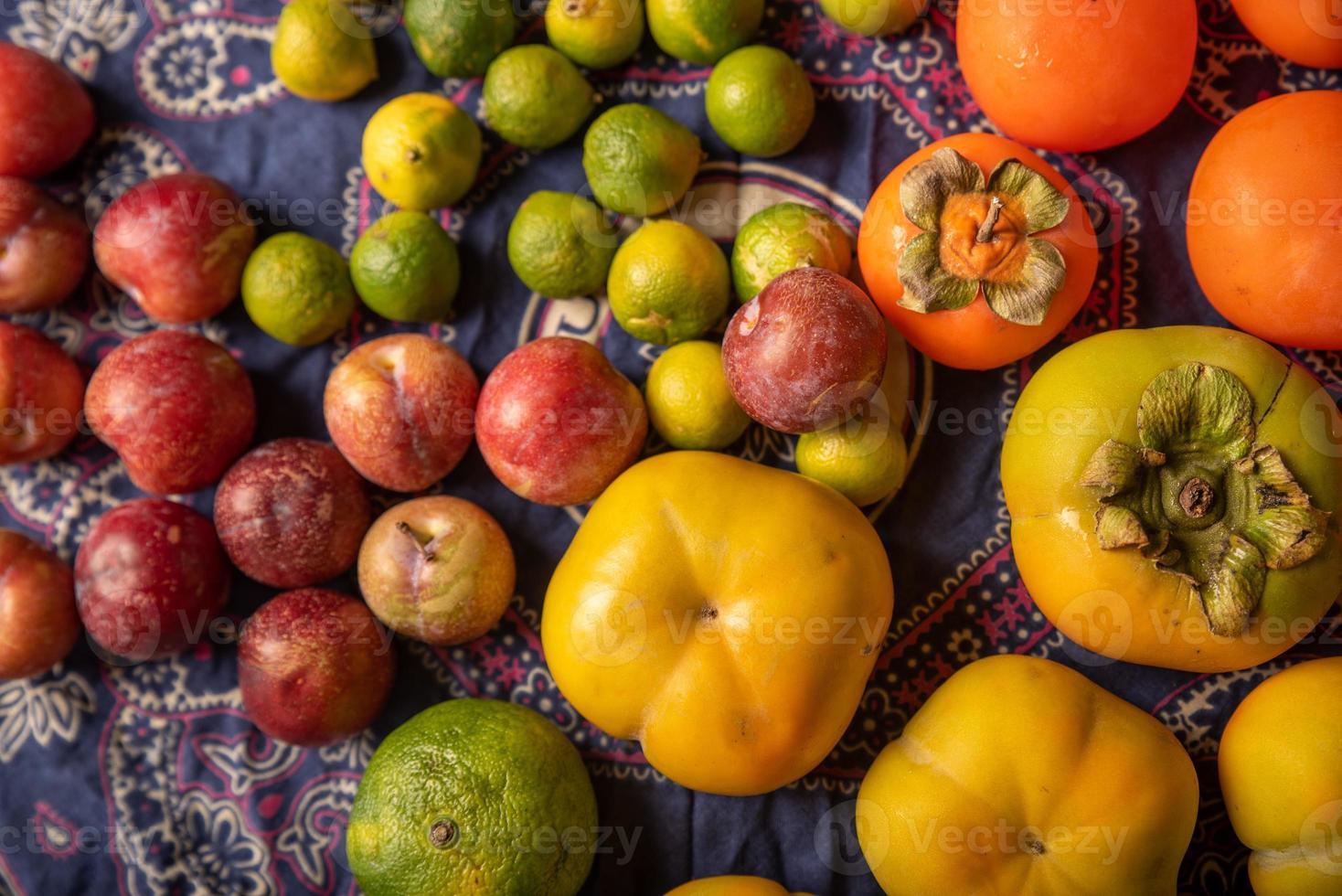 Muchos colores y variedades de frutas están en la mesa de madera. foto