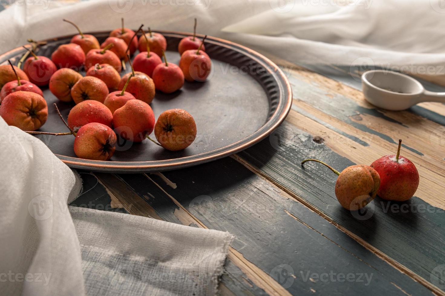 Espino rojo en un plato o esparcido sobre una mesa de madera foto