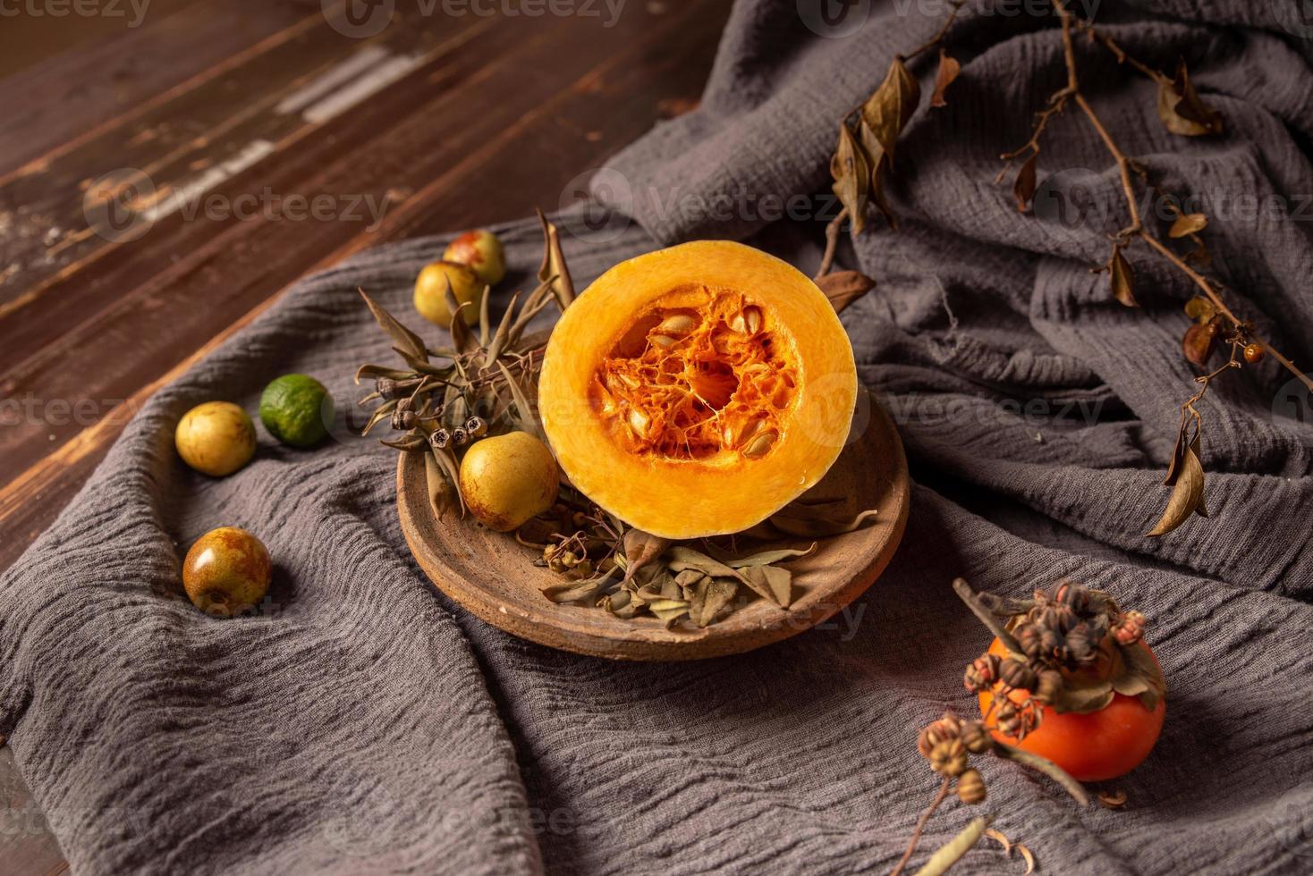 Pumpkins and many other colors and varieties of fruits and vegetables are on the wood grain table photo