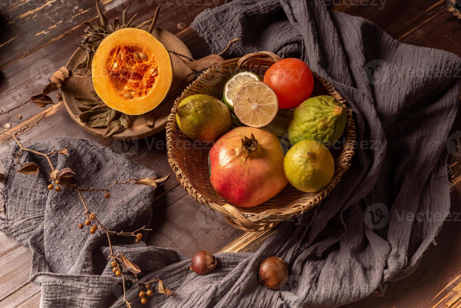 Pumpkins and many other colors and varieties of fruits and vegetables are on the wood grain table photo