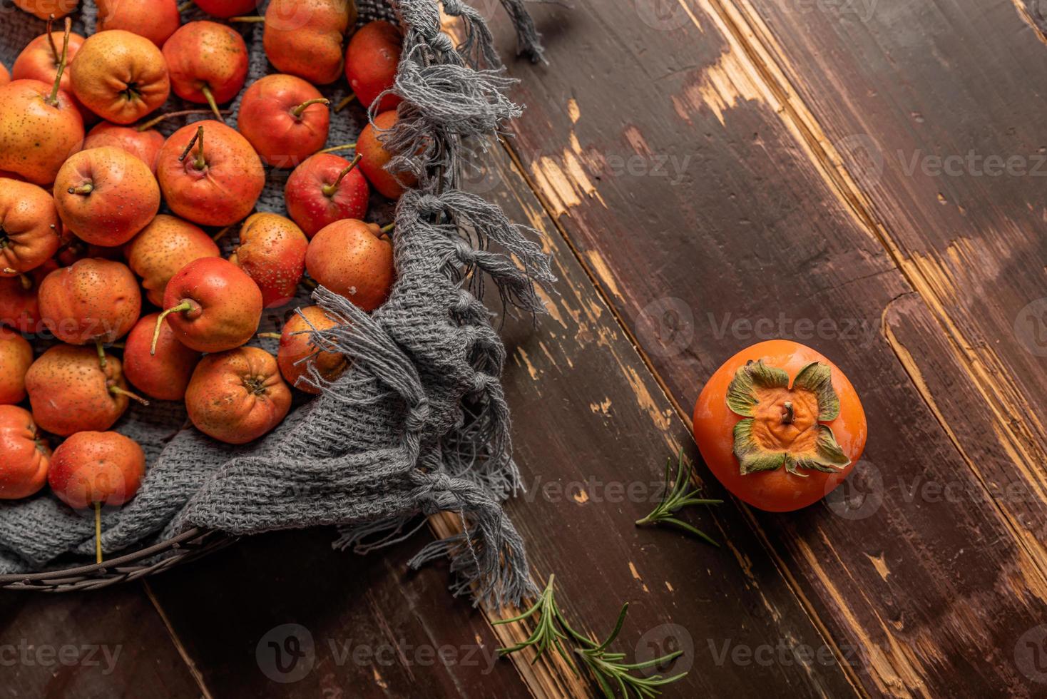 Persimmon and hawthorn are on the wooden table photo