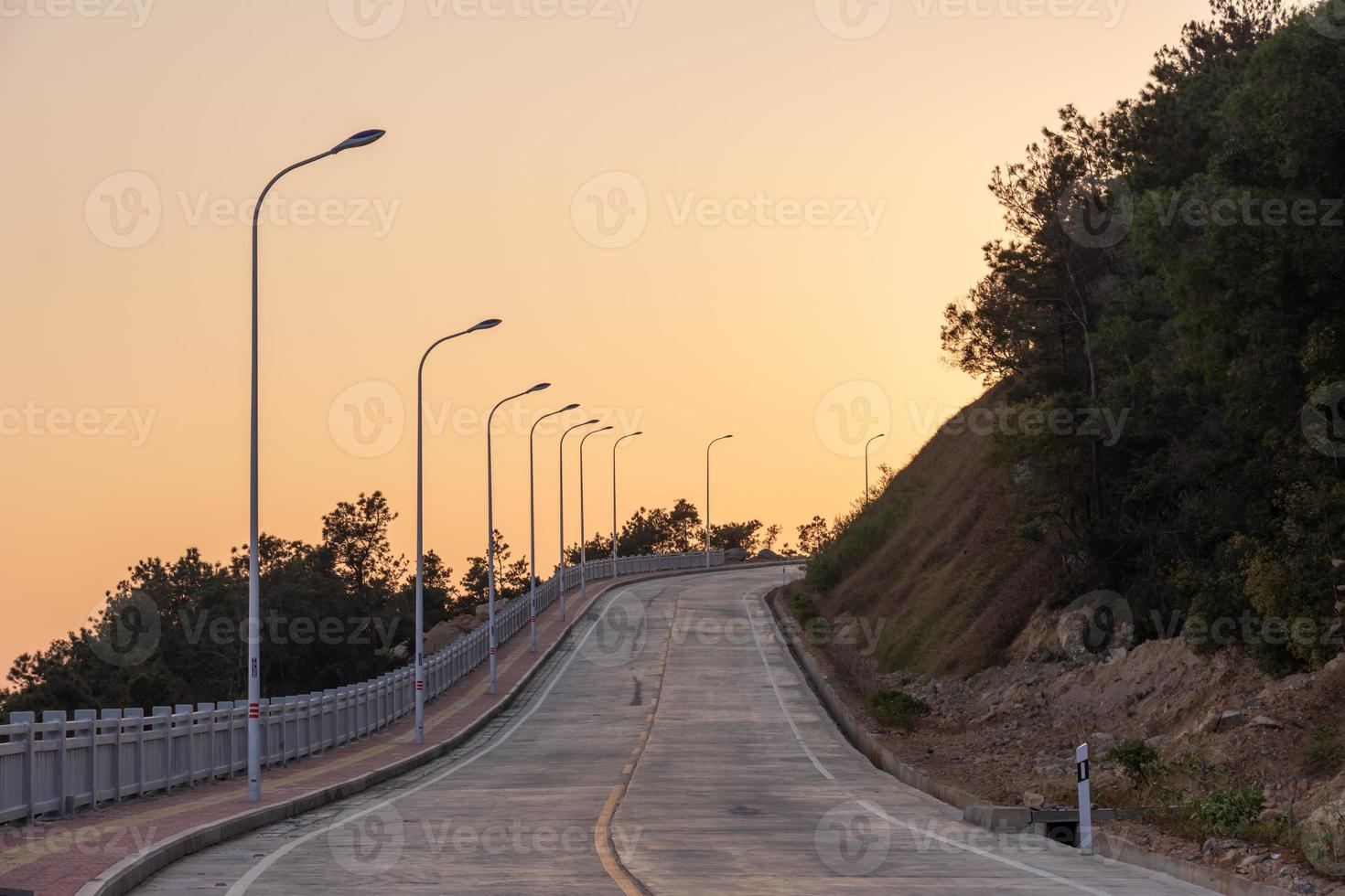 The dusk road leads to the distance, and the sky is golden photo