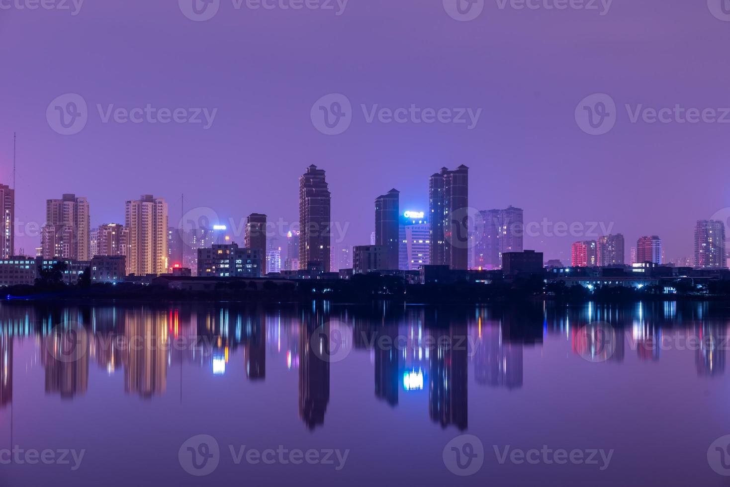 ciudad reflejada por el lago en la noche foto