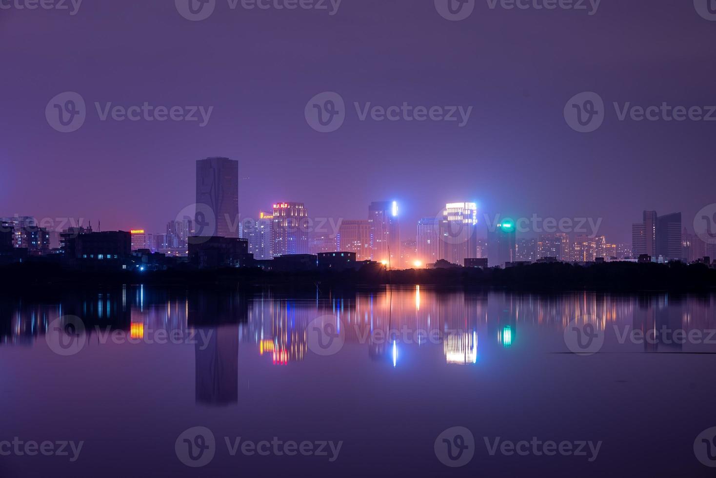 ciudad reflejada por el lago en la noche foto
