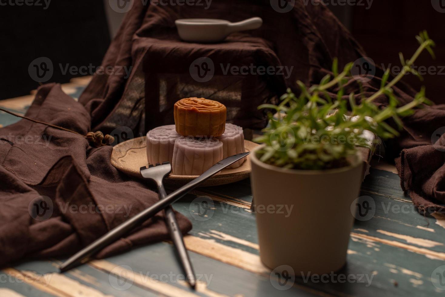 Chinese cakes are on the gray cloth of the wooden table photo