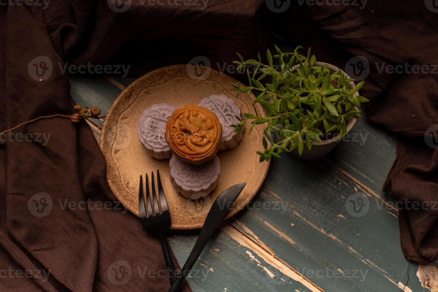 Chinese cakes are on the gray cloth of the wooden table photo