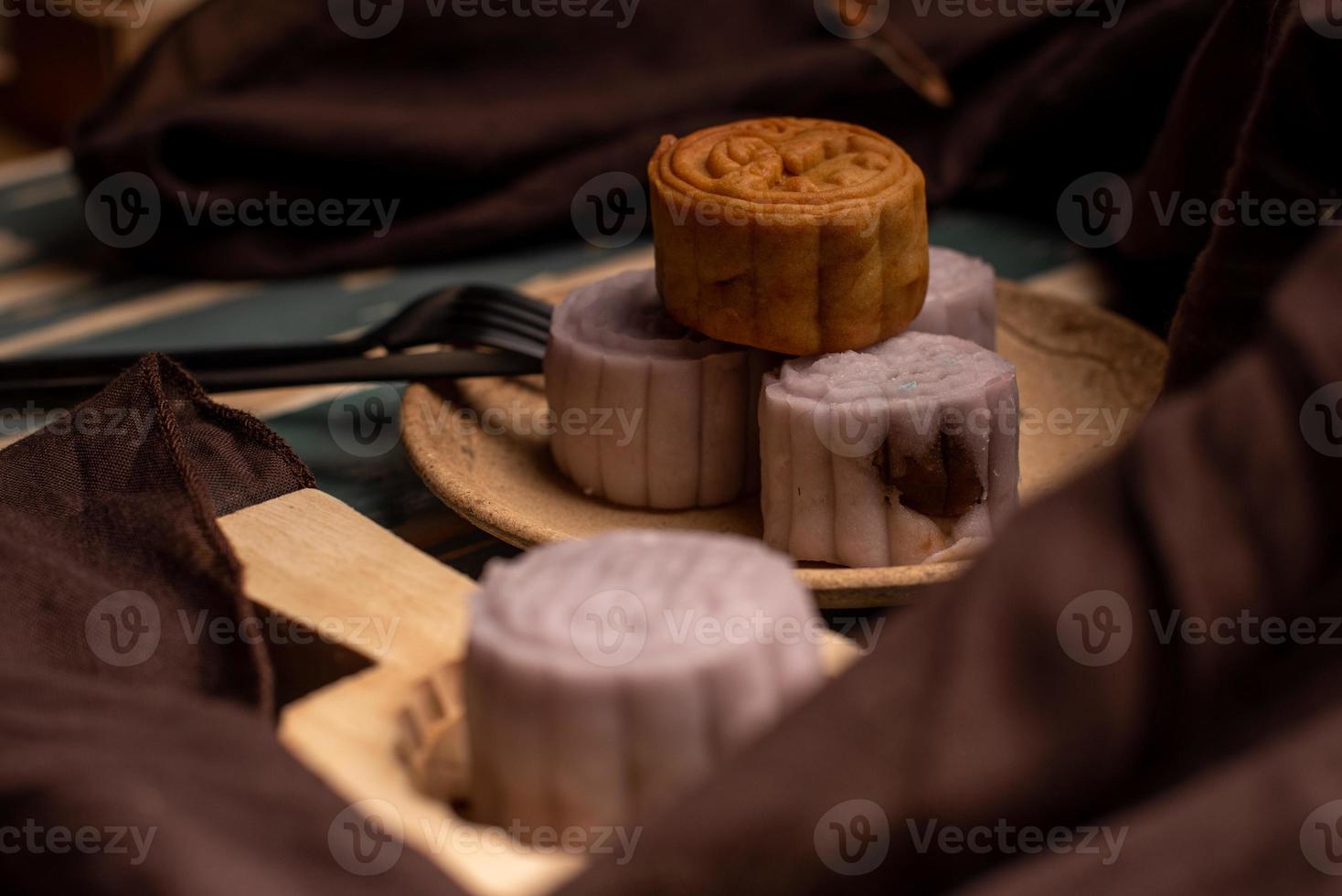 Chinese cakes are on the gray cloth of the wooden table photo