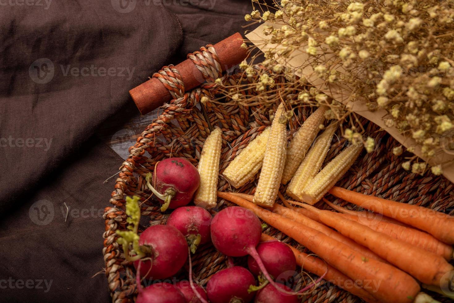 The afternoon sun shines on the red and orange radishes in the basket photo