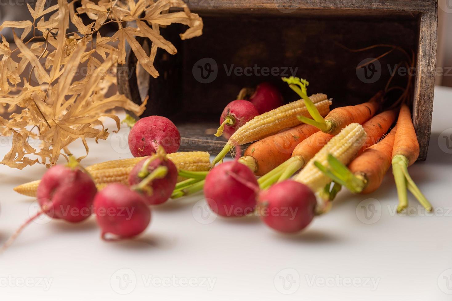 los rábanos rojos y naranjas están en la tela blanca foto