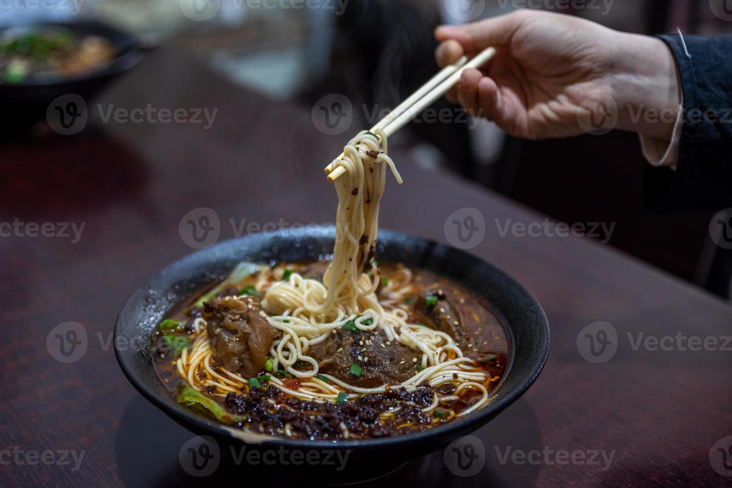 Pick up Chinese food with chopsticks photo