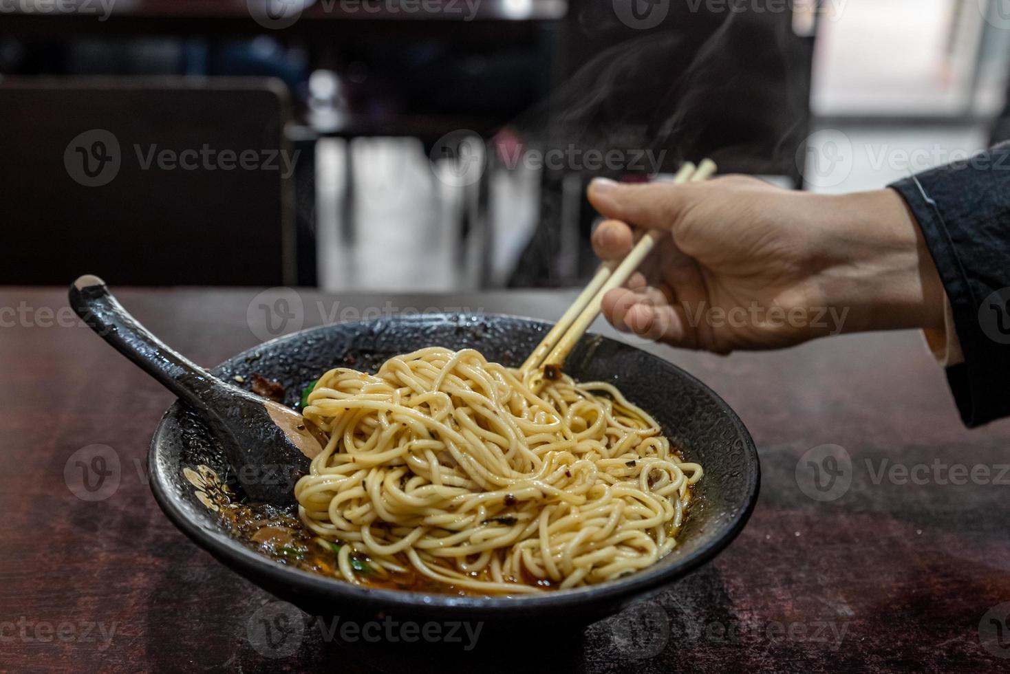 Pick up Chinese food with chopsticks photo