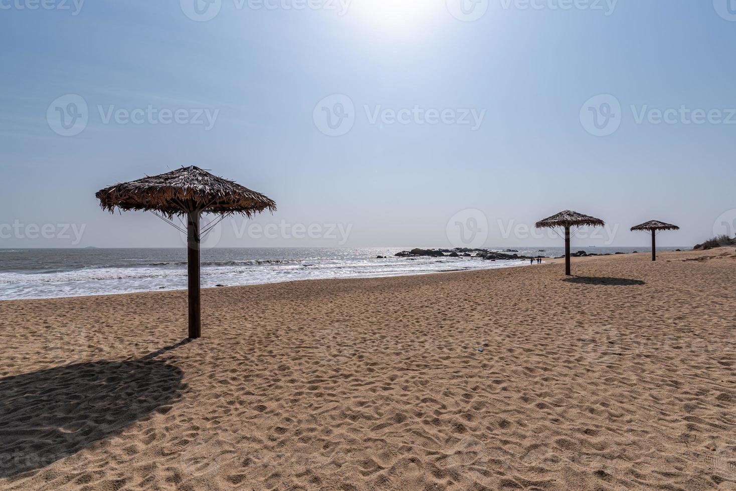 Hay sombrillas de hierba en la playa en verano. foto