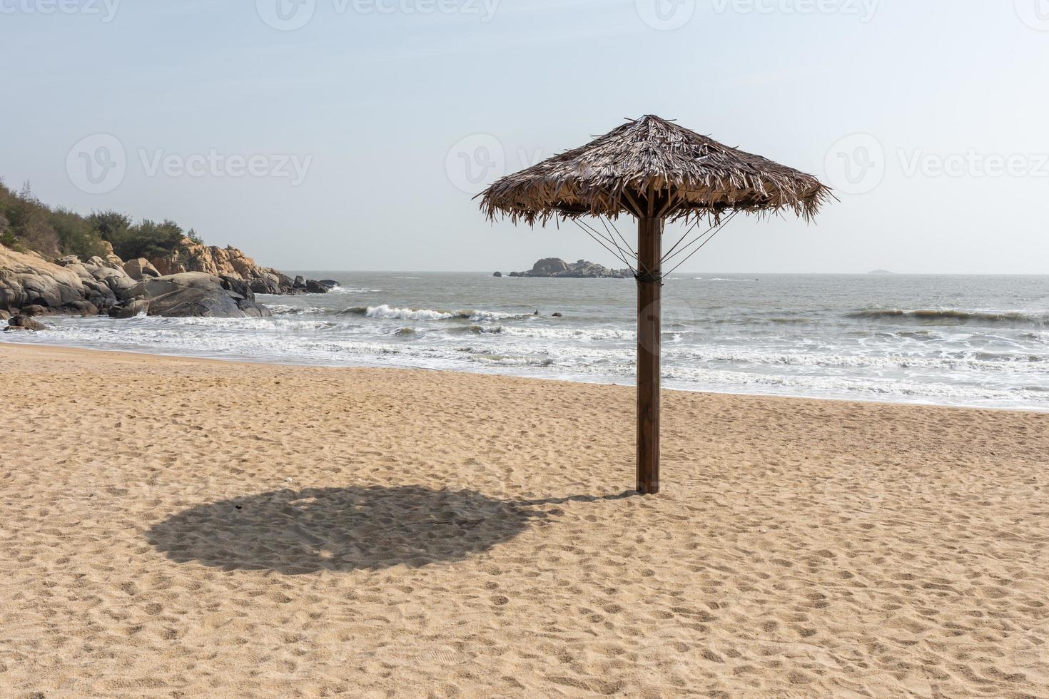 Hay sombrillas de hierba en la playa en verano. foto