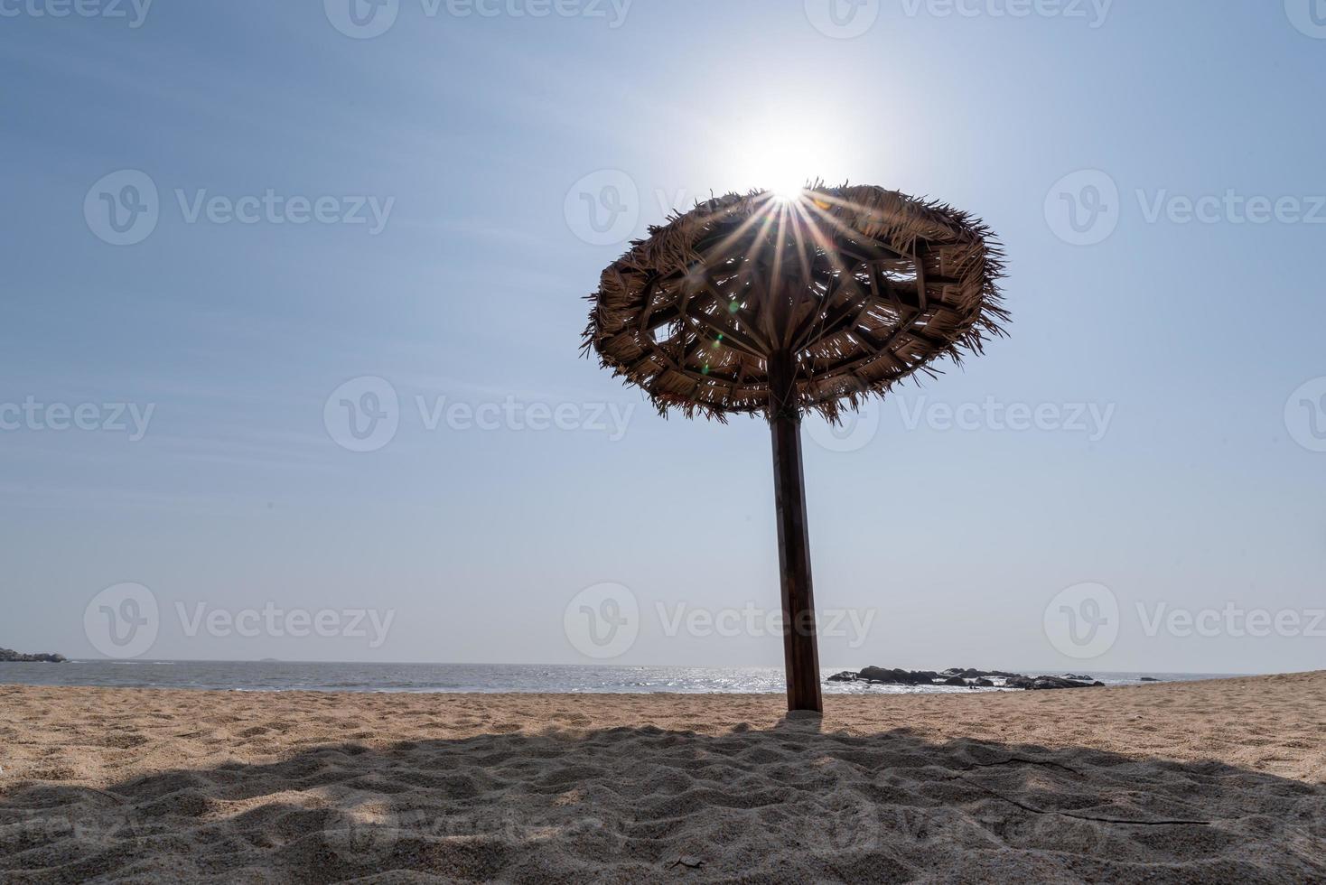 Hay sombrillas de hierba en la playa en verano. foto