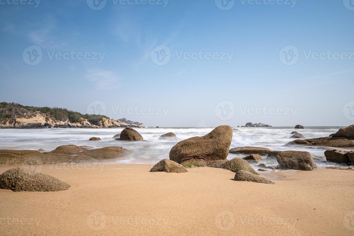 el cielo es azul en verano. el mar tiene playas doradas, olas y arrecifes foto