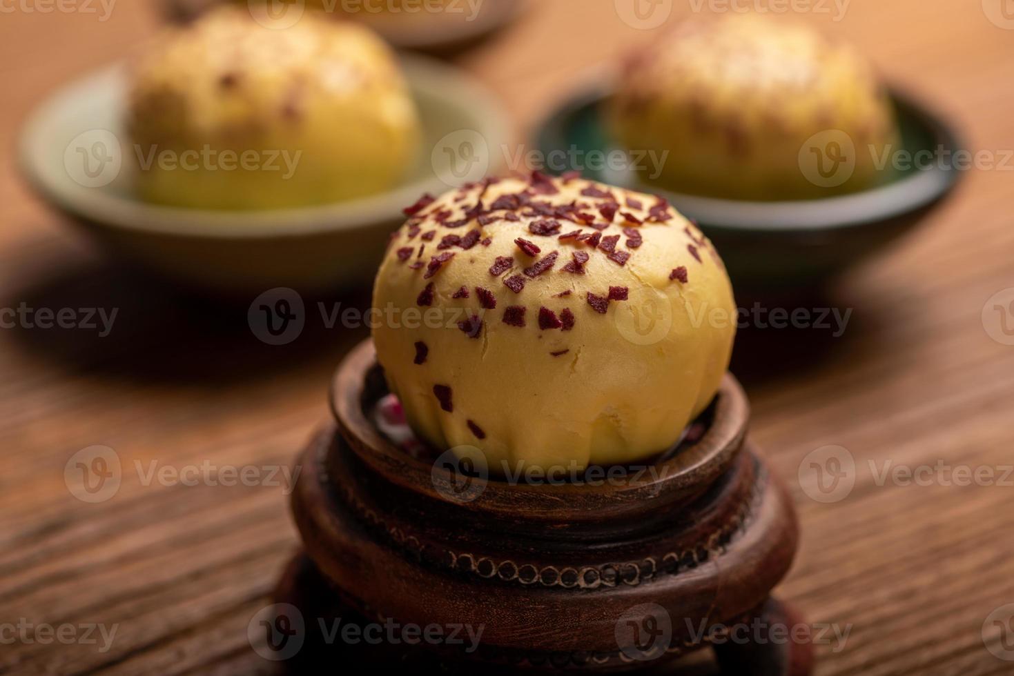 Cortar y completar el bollo relleno de yema de huevo al vapor sobre la mesa de madera. foto