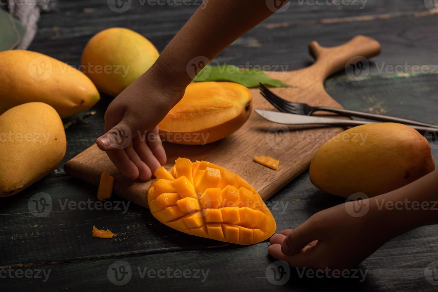 Cut and complete mangoes on the chopping board photo