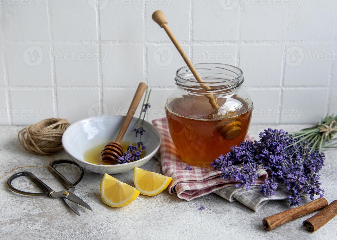 tarro con miel y flores frescas de lavanda foto