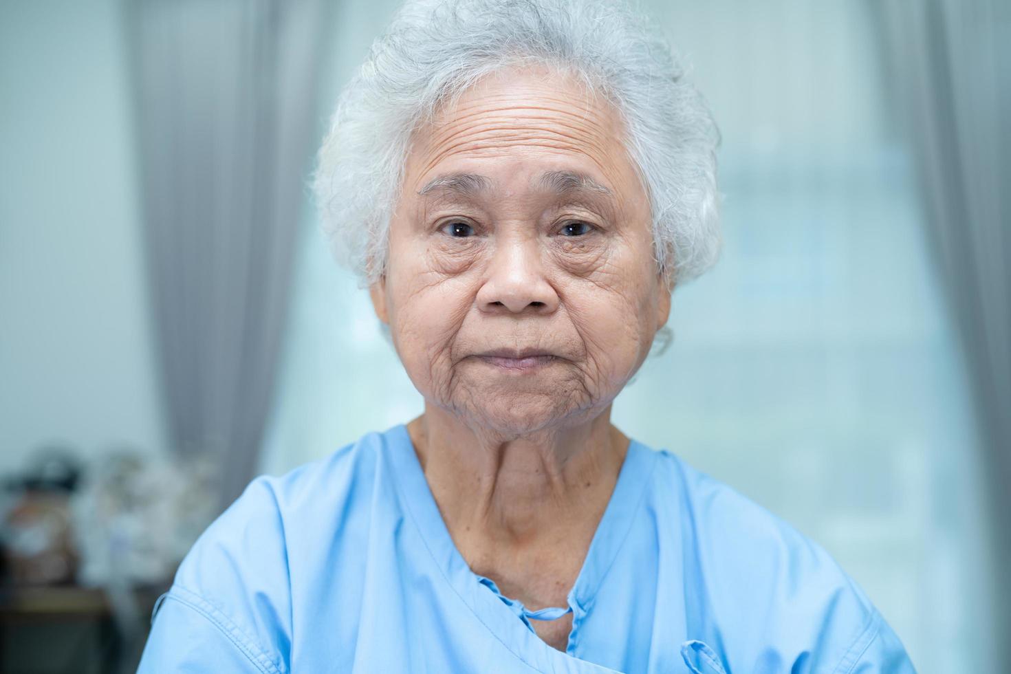 Asian senior or elderly old lady woman patient bright face while sitting in nursing hospital ward, healthy strong medical concept photo