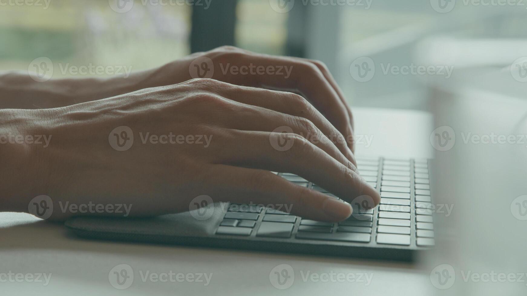 Hands of man typing on keyboard laptop photo