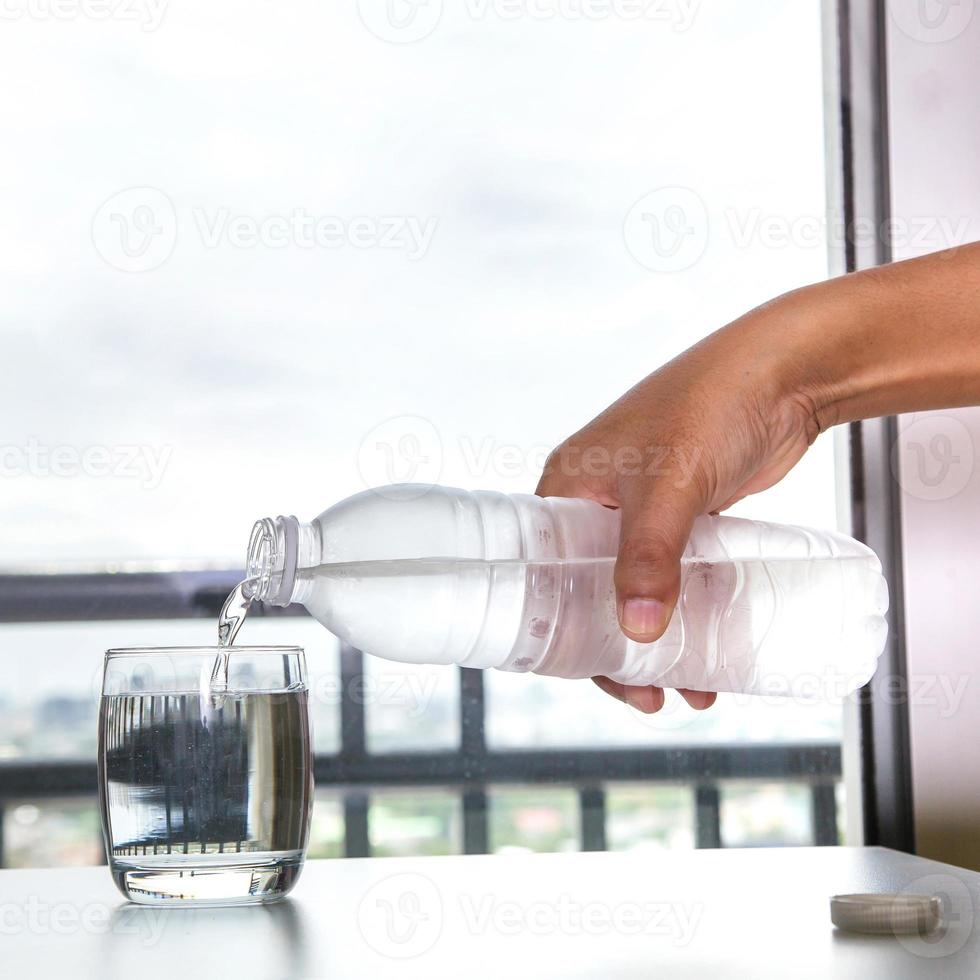 Pouring water into a glass photo