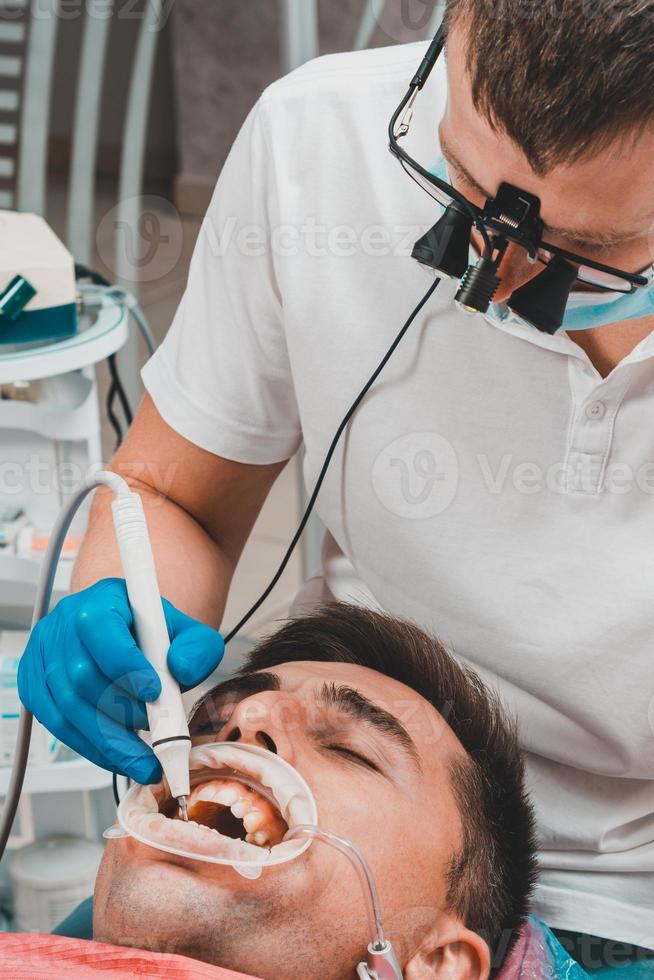 el dentista usa binoculares para obtener el mejor resultado y trabajo foto