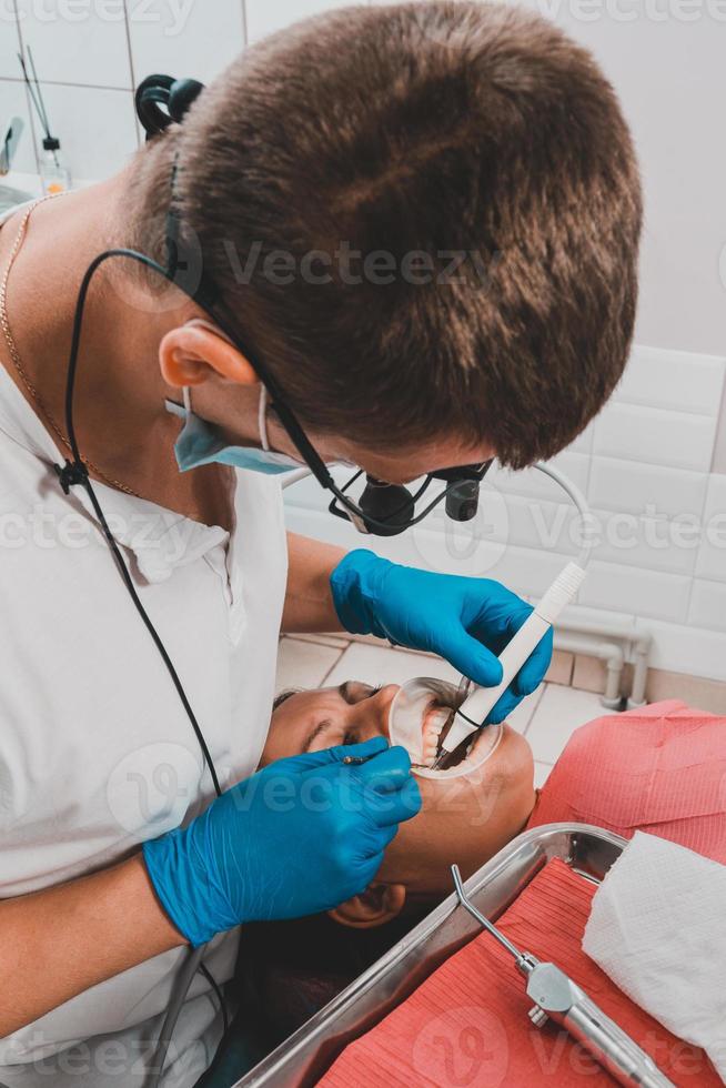 el dentista utiliza un raspador para eliminar el sarro, higiene bucal. foto