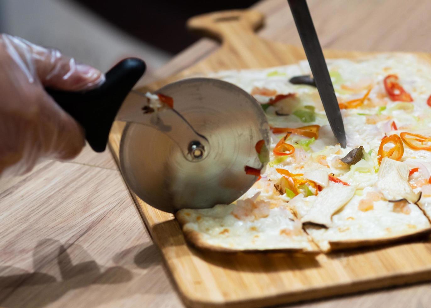 Delicious fresh pizza, closeup of pizza cutter on italian pizza photo