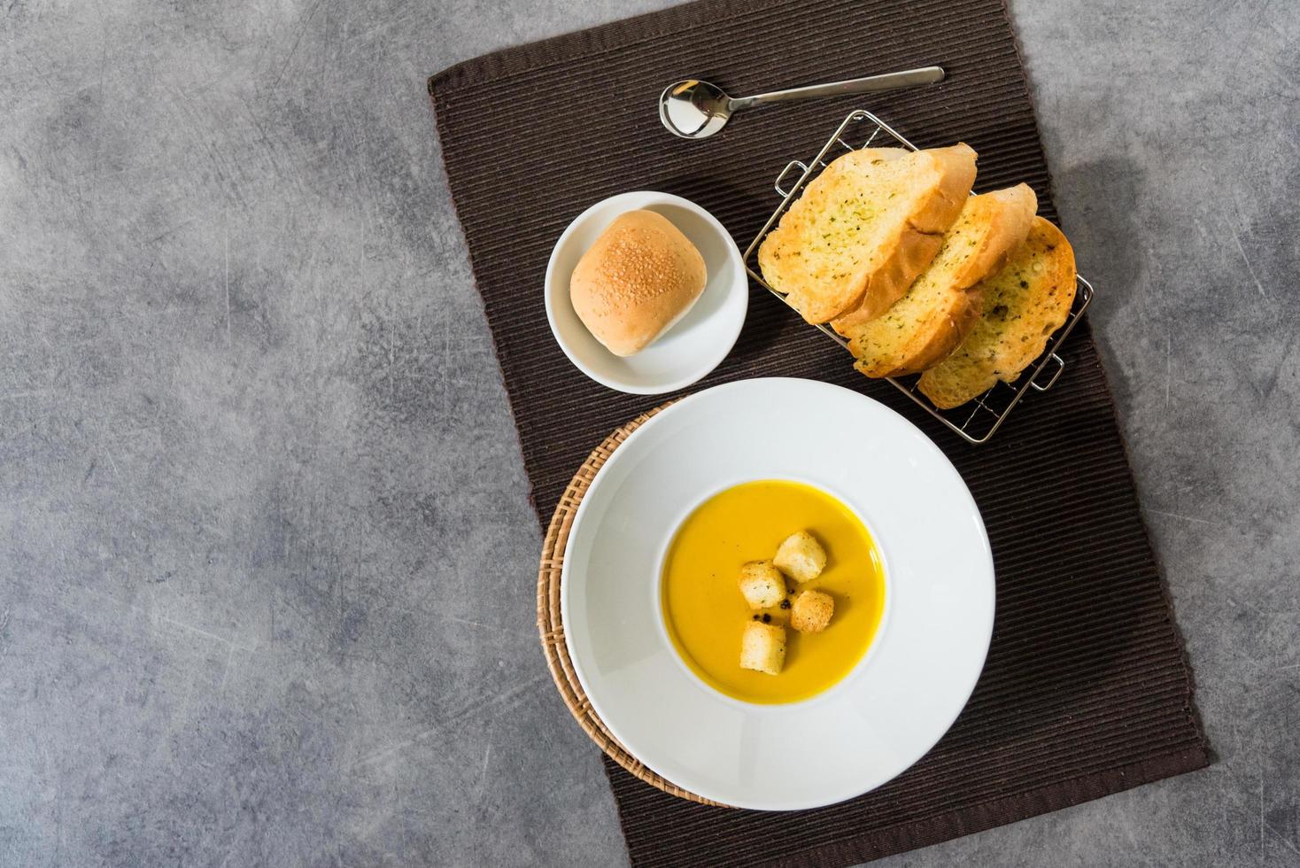 sopa de calabaza con crutones de pan en un plato de pan de ajo foto