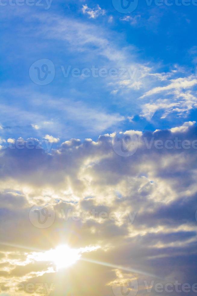 Sun shines between clouds in the sky. Blue white colors. photo