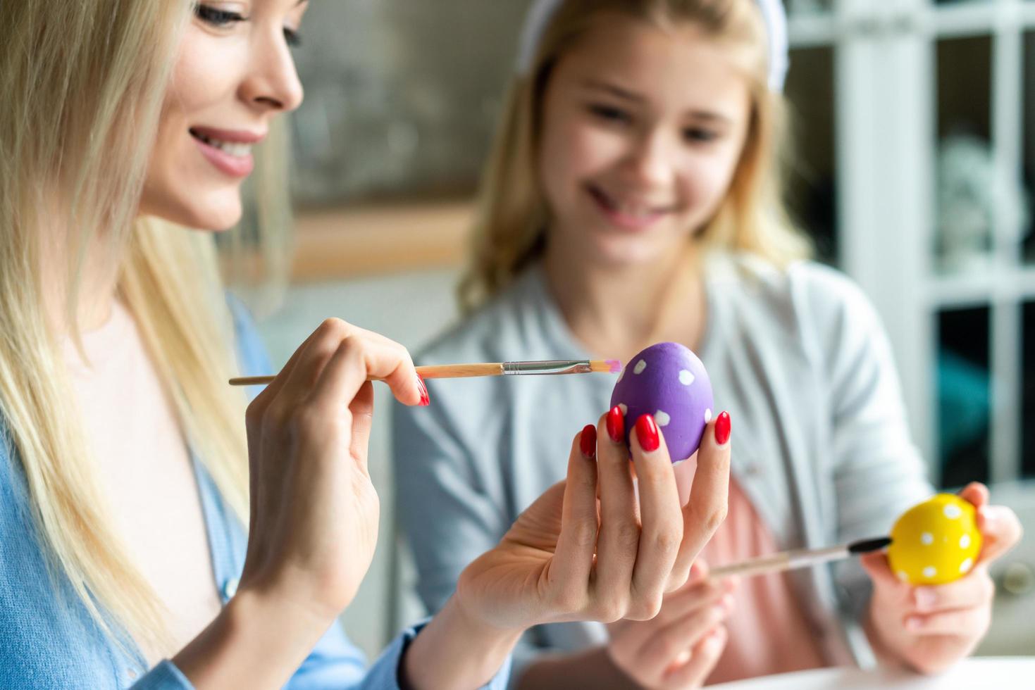 Mom with daughter coloring Easter eggs. photo