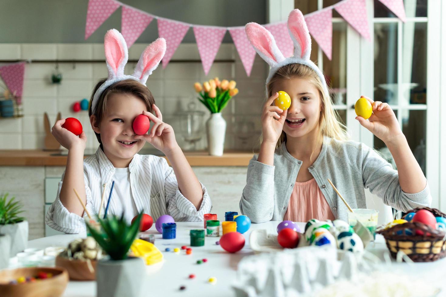 Two kids having fun playing with their eyes closed with an Easter egg. photo