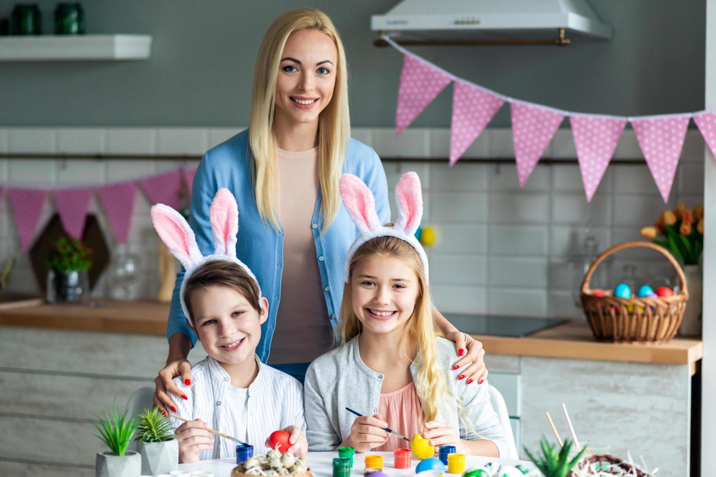 Retrato de mamá con niños, decoración de cocina de Pascua. foto