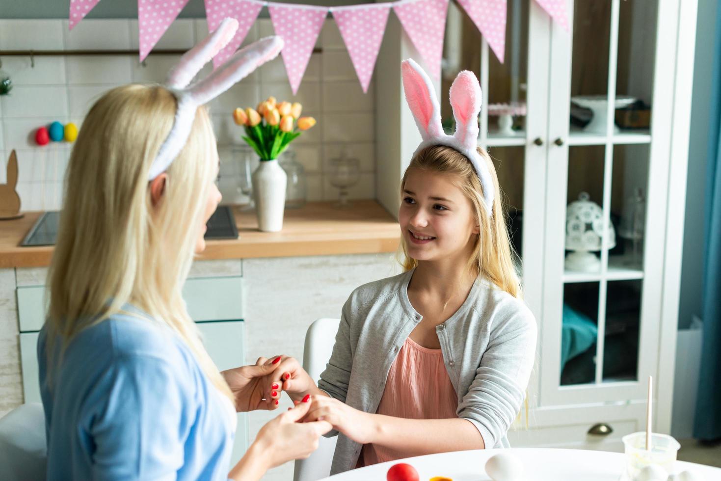 Happy family preparing for Easter. Cute little child girl wearing bunny ears on Easter day. photo