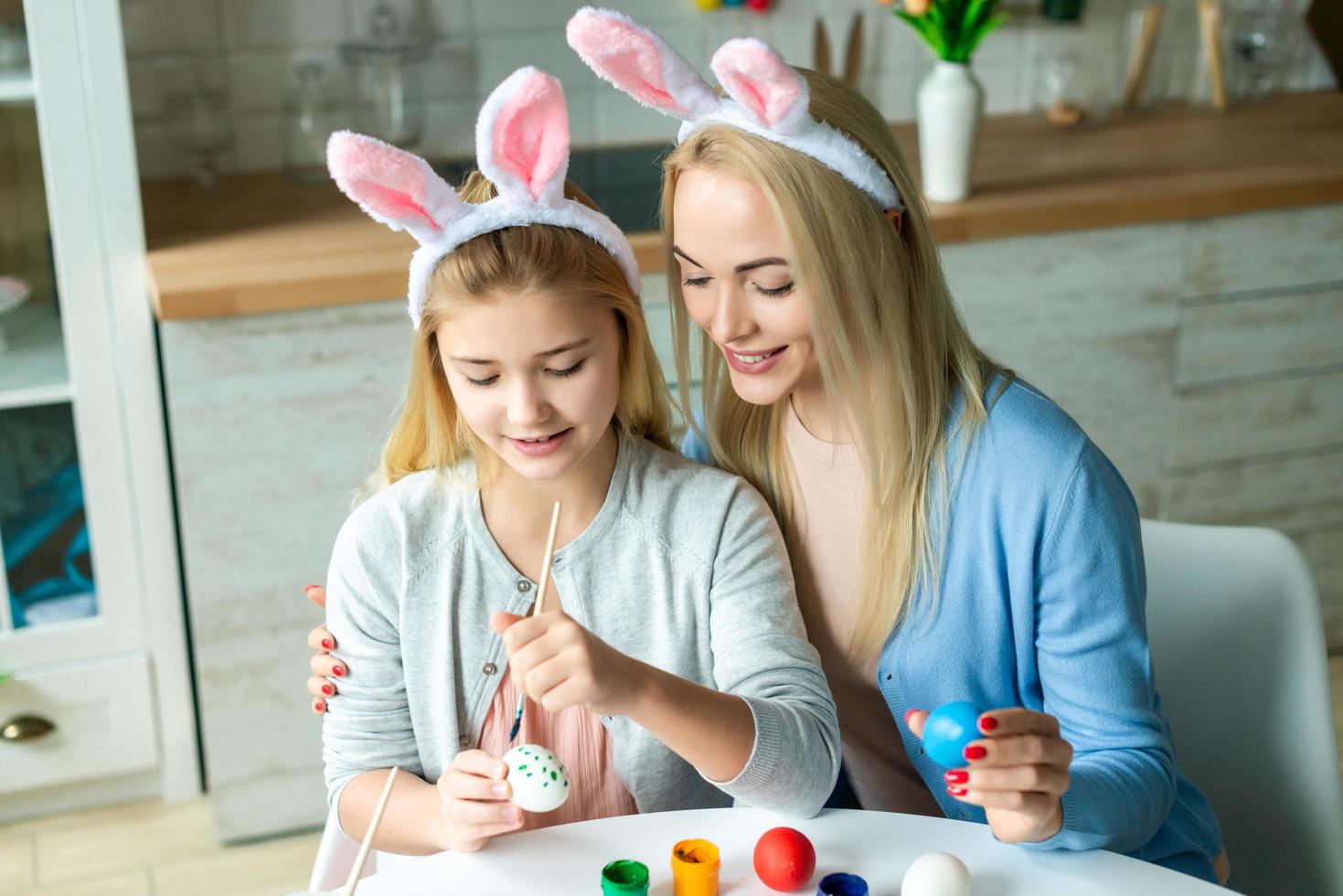 Easter holiday, easter day, Happy family, holiday concept, mother and daughters painting easter eggs. Happy family preparing for Easter. Mom and her girls playing together photo