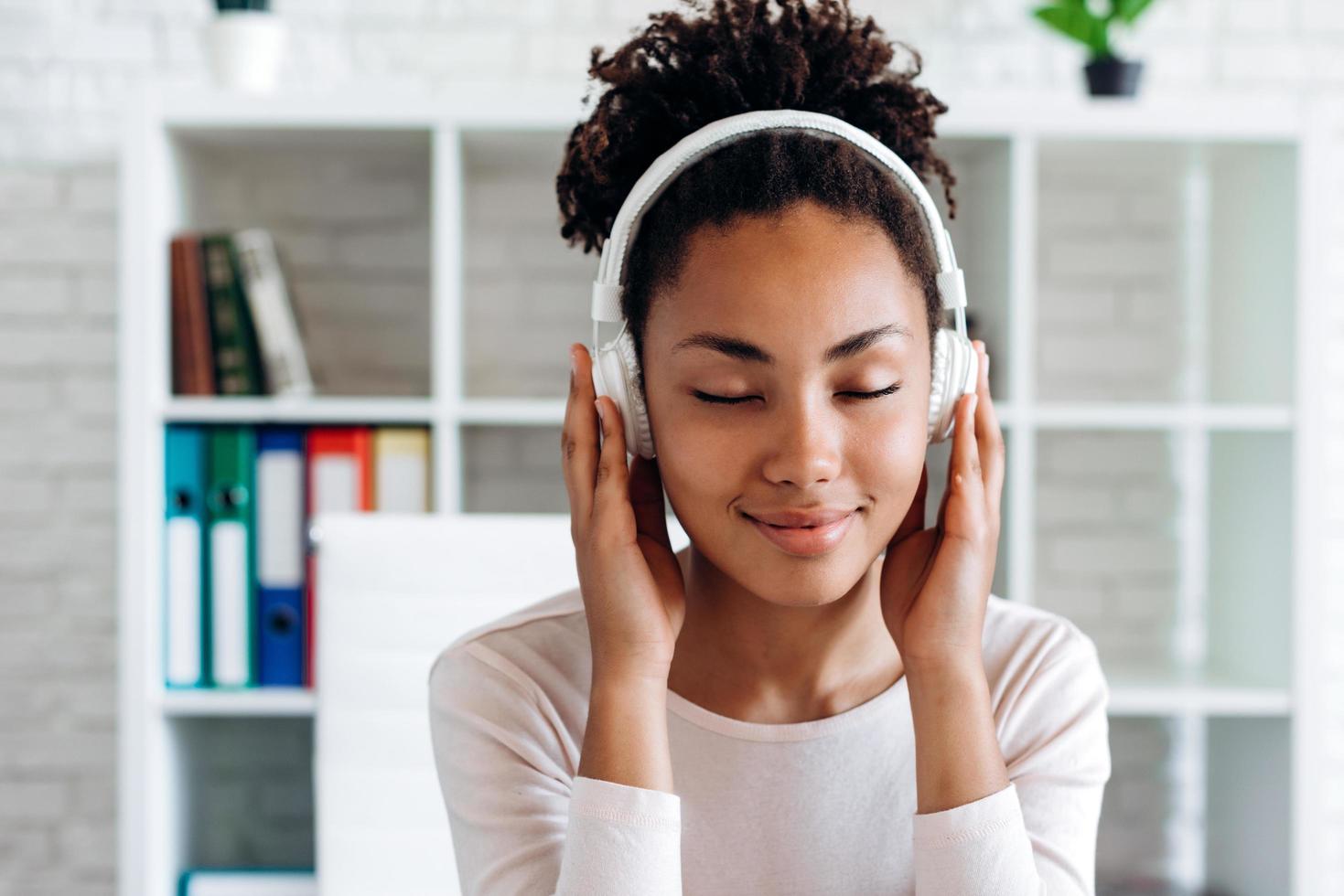 chica atractiva en auriculares disfruta de la música que se escucha foto