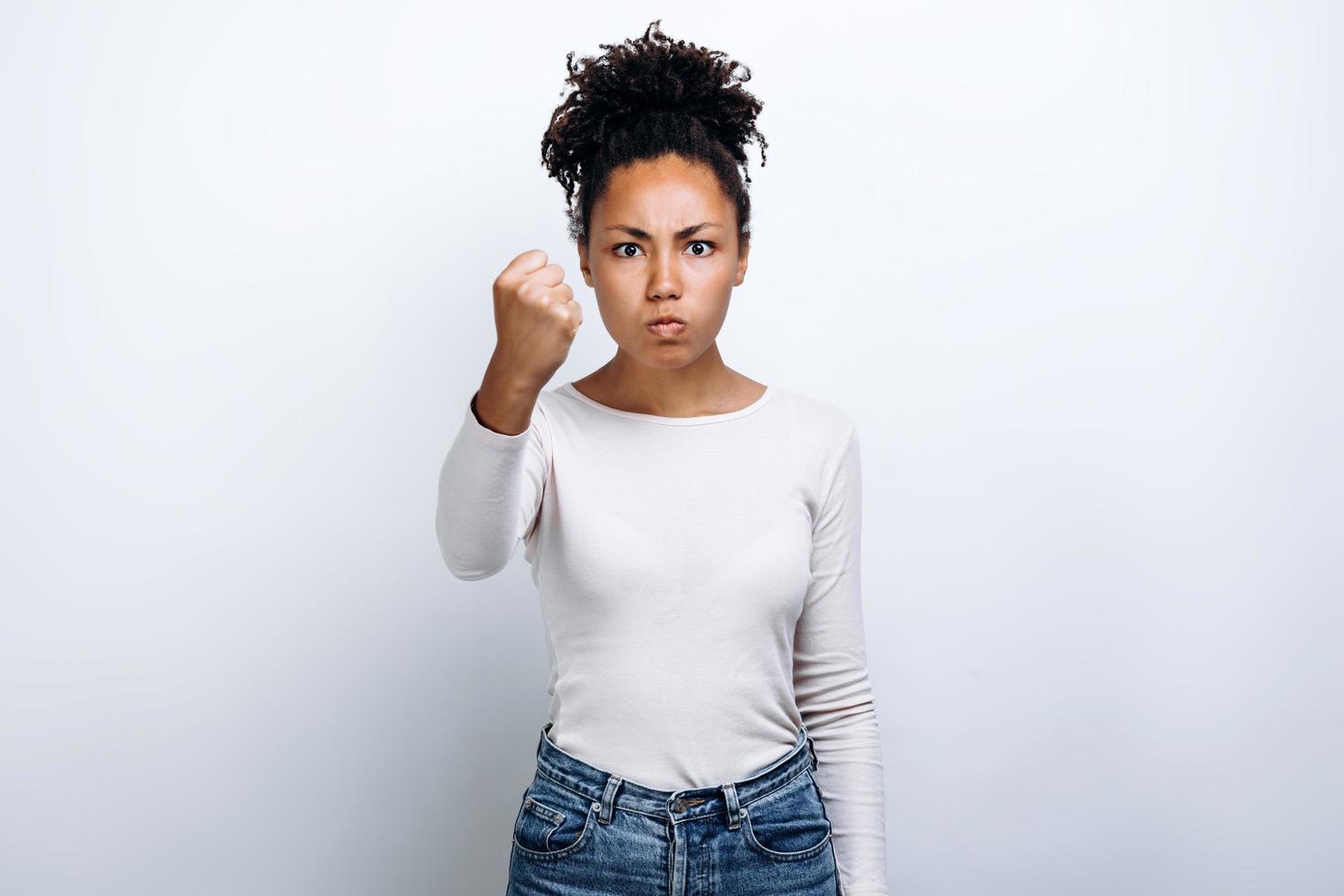 Young girl on white background shows his fist. Female force. photo