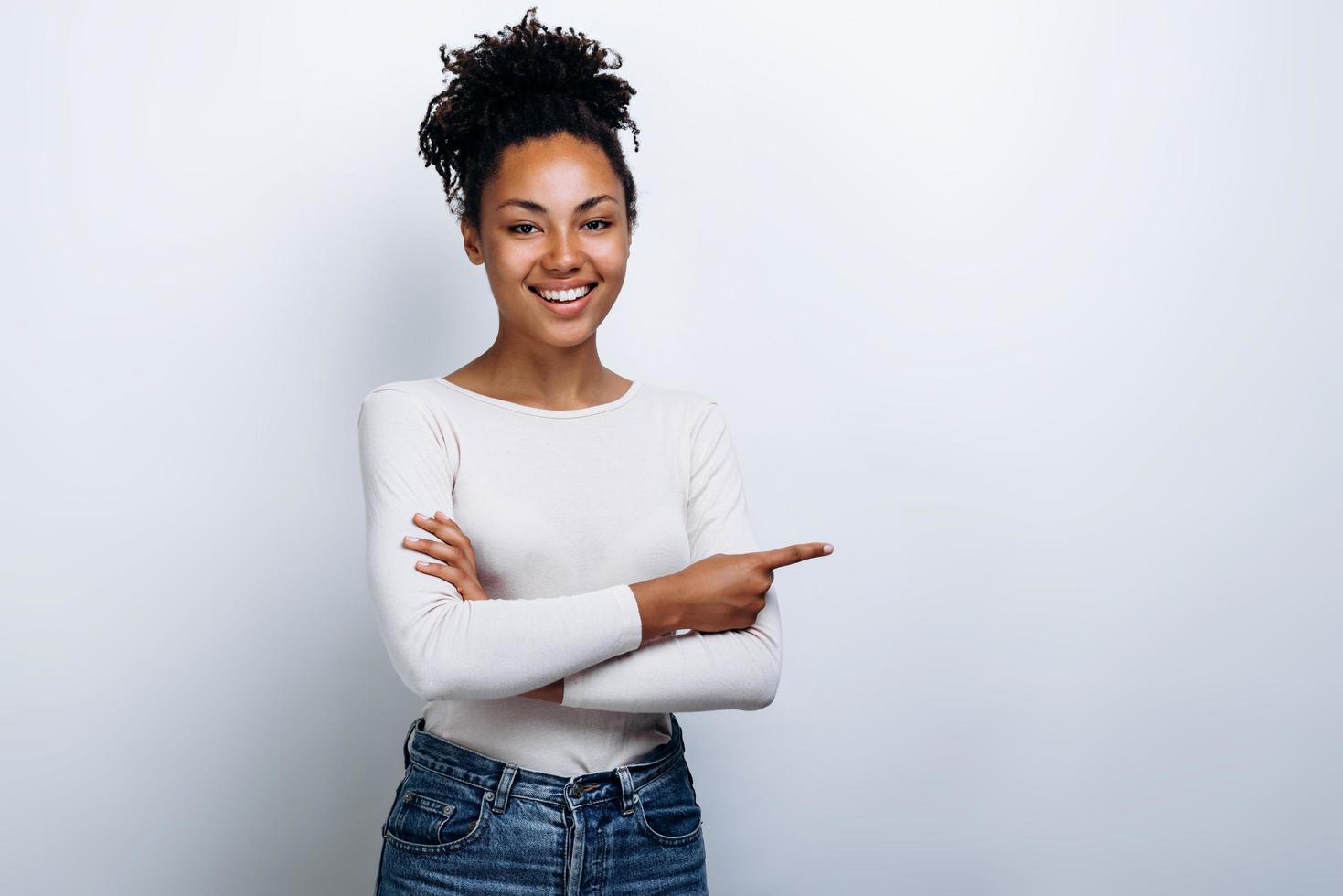 Young, beautiful girl with curly hair shows a finger on a copy space photo