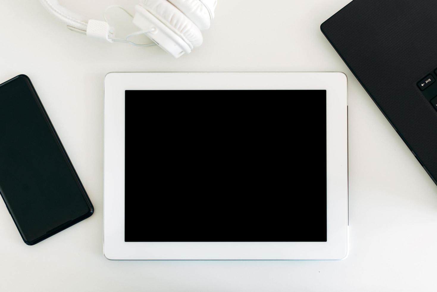 en una mesa brillante hay una tableta con una pantalla en blanco foto