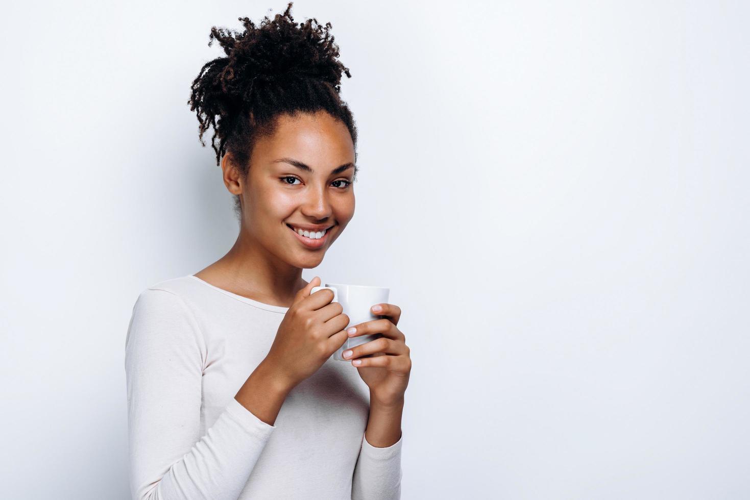 Portrait of happy woman thinking and looking into camera on white background photo