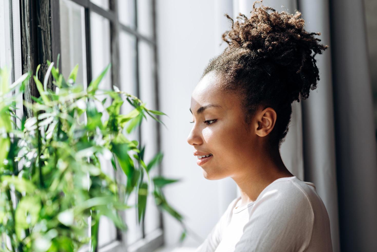 Cute, beautiful girl looking out the window of her house photo